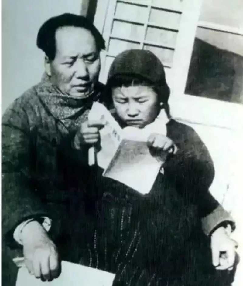 1946年毛泽东在延安窑洞前教女儿李讷识字。.jpg